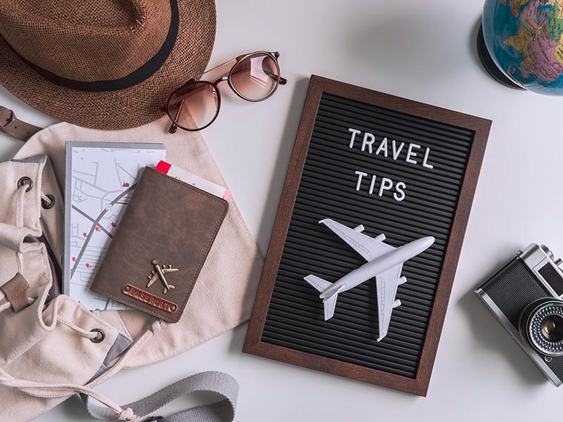 Retro camera with toy plane, map and passport on white background, Travel tips concept
